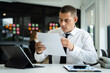 © NINENII - Business man working at office with laptop and documents on his desk, financial adviser analyzing data.
