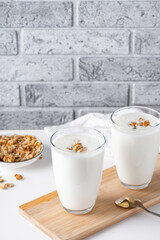 Wall Mural - Kefir, buttermilk or yogurt with granola. Yogurt in glass on light background. Probiotic cold fermented dairy drink. Gut health, fermented products, healthy gut flora concept. Copy space