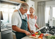 © Kay Abrahams/peopleimages.com - Senior couple, cooking and having fun while preparing a healthy food with vegetables for a vegan meal in the kitchen at home while laughing and having fun. Funny old man and woman helping with dinner