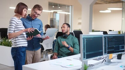 Wall Mural - happy young caucasian managers discussing market data using laptop and speaking in modern office. op