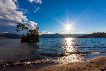 Sticker - 春の青森県・十和田湖で見た、夕暮れに差し掛かる時間の太陽と快晴の青空