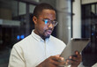 © N Lawrenson/peopleimages.com - Tablet research, night planning and businessman working on email on the internet while in a dark office at work. Corporate African employee reading communication online on tech while doing overtime