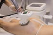 Hardware anti-cellulite massage. RF lifting procedure. The beautician guides the device along the client's buttock. Ultrasound cavitation body contouring treatment. Anti-fat therapy.
