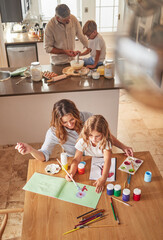 Family, mother and girl learning painting and education in the home from above. Development, growth and kids, parents and baking in kitchen with father, bonding and care, support and love in house.