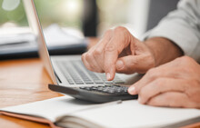 Calculator, Laptop And Hands Of Man Calculating, Accounting And Home Budget While Doing Online Payments And Sitting At A Table At Home. Closeup Of A Mature Male Accountant Doing Finance Planning