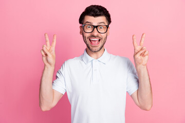 Poster - Portrait photo of young attractive handsome funny man wear eyeglasses showing v-sign two hands positive excited good mood isolated on pink color background