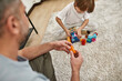 © Svitlana - Cropped dad and son play with construction blocks