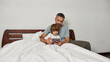 © Svitlana - Father and little son watch digital tablet in bed