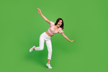 Sticker - Full size photo of lovely positive woman with wavy hairstyle dressed white pants blouse look down fall isolated on green color background