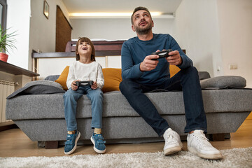 Wall Mural - Surprised little boy and father playing video game