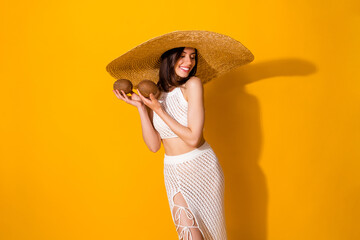 Poster - Photo of sweet dreamy lady wear white outfit hat holding two coconuts smiling isolated yellow color background