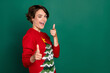 Photo of funny brown hair young lady wink index camera wear red ugly sweater isolated on green color background