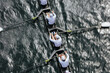 © Mint Images - Overhead view of female crew racers rowing in an octuple racing shell, an eights team.