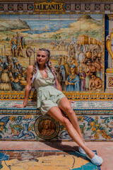 Wall Mural - Stylish fashion model in green color outfit posing in Seville old town.