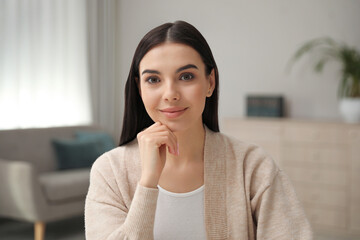 Wall Mural - Beautiful young woman conducting webinar in room, camera view