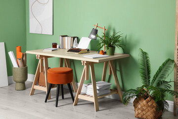 Wall Mural - Writer's workplace with typewriter on wooden desk near pale green wall in room