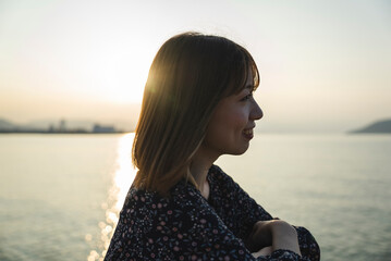 夕暮れの海にいる女性