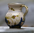 Close-up photo of a decorated ceramic water jug outdoors on a rainy day