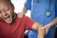 Nurse Or Sanitary Exploring Arm Injury, Dislocated Shoulder Of The Patient