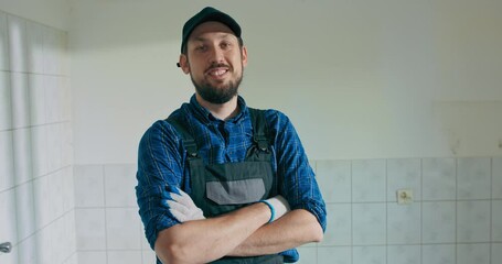 Wall Mural - Portrait of a smiling man hired to work on a construction site. The man is standing in a room undergoing demolition resting. break from the renovations.