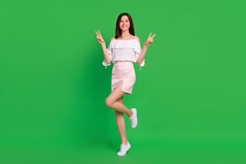 Wall Mural - full body portrait of cheerful lovely lady hands fingers demonstrate v-sign isolated on green color 