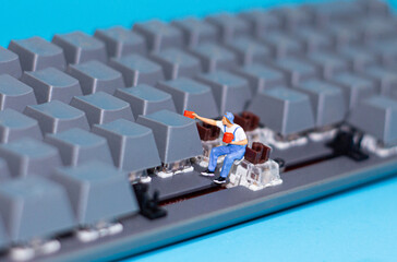 miniature people is cleaning the keyboard