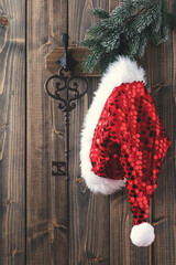 Wall Mural - Red santa hat hanging on wooden wall.