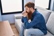 © Krakenimages.com - Young redhead man stressed sitting on sofa at home