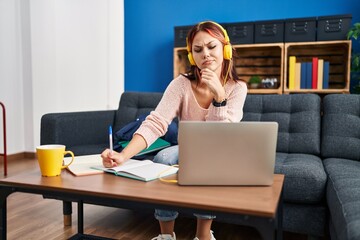 Sticker - Young caucasian woman working using computer laptop serious face thinking about question with hand on chin, thoughtful about confusing idea