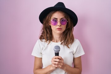 Canvas Print - Beautiful brunette woman singing song using microphone relaxed with serious expression on face. simple and natural looking at the camera.