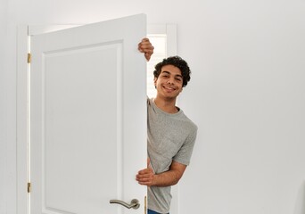 Canvas Print - Young hispanic man smiling happy opening door of new home.