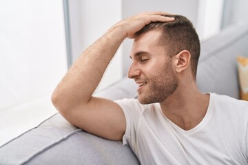 Canvas Print - Young caucasian man smiling confident sitting on sofa at home