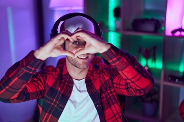 Canvas Print - Young caucasian man streamer smiling confident doing heart symbol with hands at gaming room