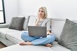 © Krakenimages.com - Young caucasian woman using laptop at home sitting on the sofa looking stressed and nervous with hands on mouth biting nails. anxiety problem.