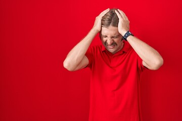 Wall Mural - Caucasian man with mustache standing over red background suffering from headache desperate and stressed because pain and migraine. hands on head.