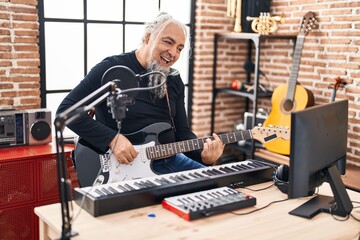 Sticker - Middle age grey-haired man musician singing song playing electrical guitar at music studio