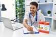 © Krakenimages.com - Young hispanic man wearing doctor uniform working at clinic