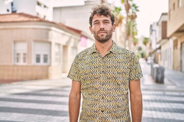 Poster - Young hispanic man standing at the street with serious expression on face. simple and natural looking at the camera.