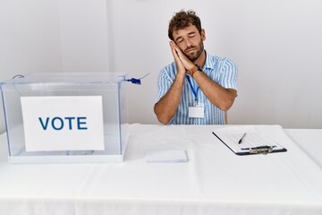 Sticker - Young handsome man at political election sitting by ballot sleeping tired dreaming and posing with hands together while smiling with closed eyes.