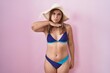 © Krakenimages.com - Young hispanic woman wearing bikini over pink background cutting throat with hand as knife, threaten aggression with furious violence