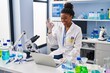 © Krakenimages.com - Young african american with braids working at scientist laboratory with laptop doing ok sign with fingers, smiling friendly gesturing excellent symbol