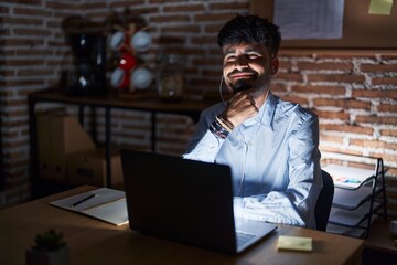 Sticker - Young hispanic man with beard working at the office at night looking confident at the camera smiling with crossed arms and hand raised on chin. thinking positive.