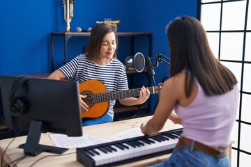 Sticker - Two women musicians playing classical guitar and piano at music studio