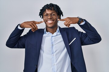 Sticker - Young african man with dreadlocks wearing business jacket over white background smiling cheerful showing and pointing with fingers teeth and mouth. dental health concept.