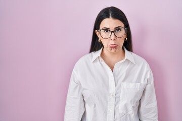 Poster - Young brunette woman standing over pink background depressed and worry for distress, crying angry and afraid. sad expression.