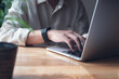 © tippapatt - Business man working on laptop computer, typing on laptop keyboard on office table, surfing the internet, online job, online study, e-learning, working at home, telecommuting concept
