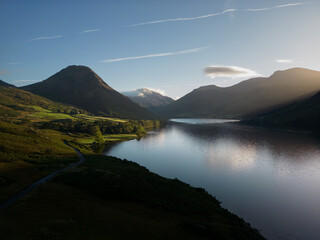 The sun lights up trees on the shore of Wastwater in the lake district