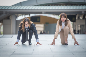 2023 new start, two business woman getting ready for race in business on the city background, business competition concepts.