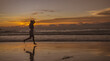 © waragron - Silhouette of young Asian woman relaxing on a sandy beach at sunset