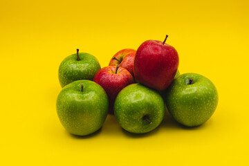 green apples and red apples on yellow background